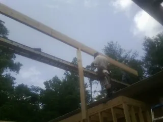 Carpenter setting a ridge beam over a new addition frame — Ice Dam Removal by Roofing Brothers in New Bloomington