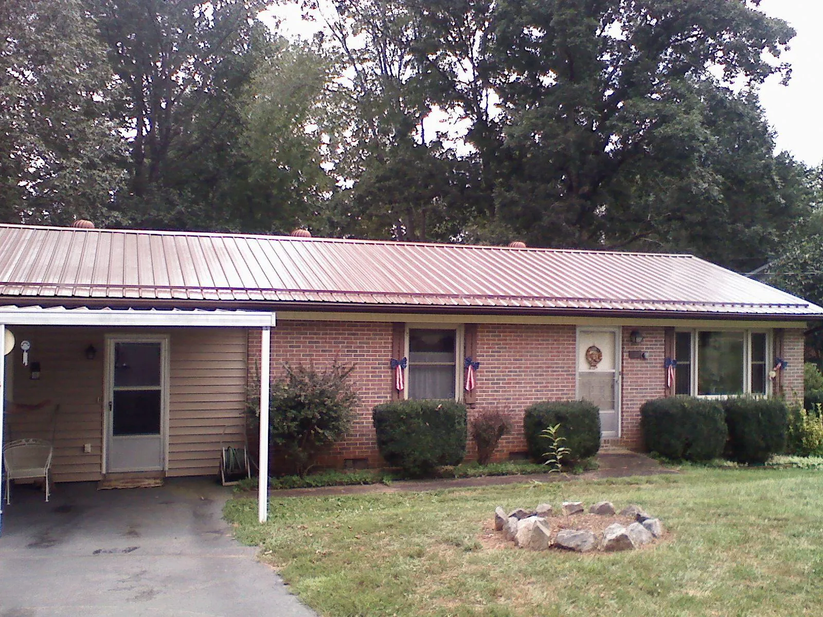 Bronze metal roof and carport on a brick ranch home — Roof Repair work by our crew in New Bloomington