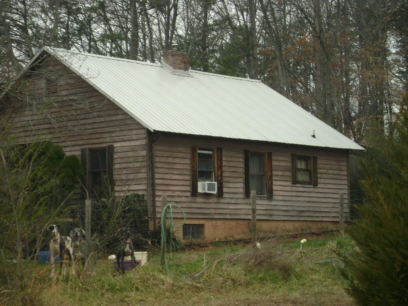 White metal roof on an old wood sided farmhouse, from a Metal Roof Installation job in New Bloomington